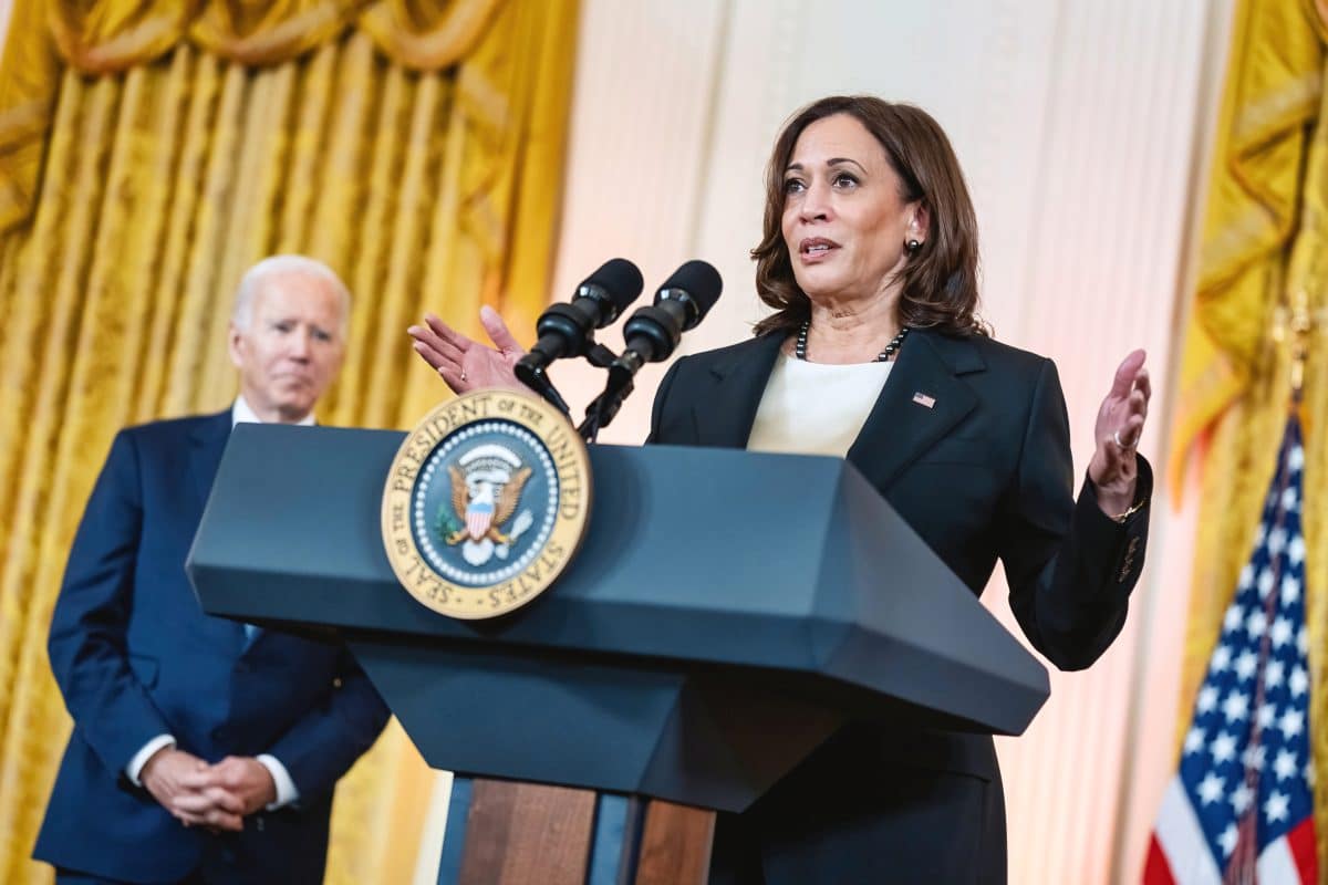 Kamala Harris speaking with President Joe Biden behind her